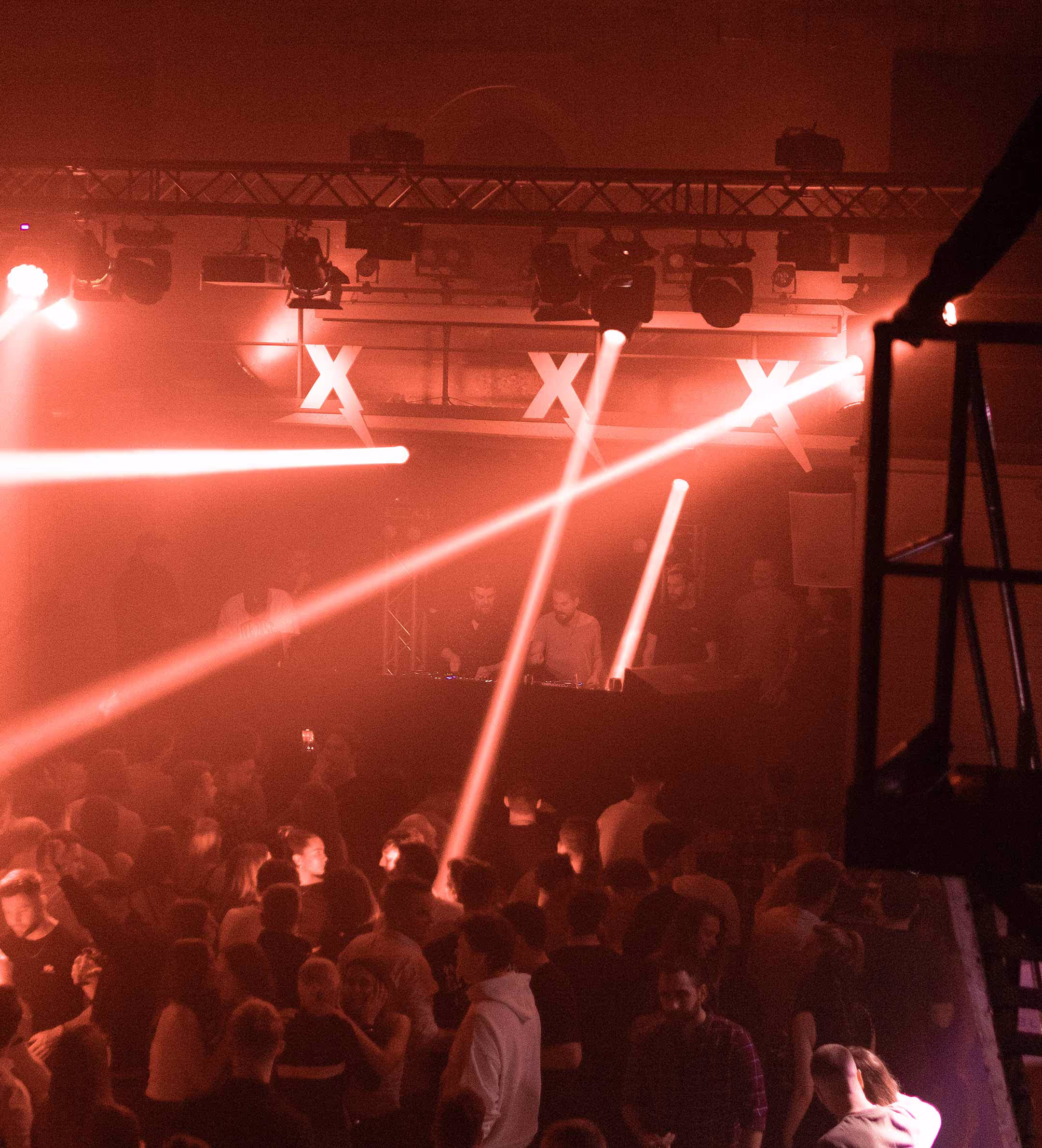 Menschen tanzen auf einer Veranstaltung wo ein DJ auflegt und die Scheinwerfer leuchten bunt Menschen tanzen auf einer Veranstaltung wo ein DJ auflegt und die Scheinwerfer leuchten bunt